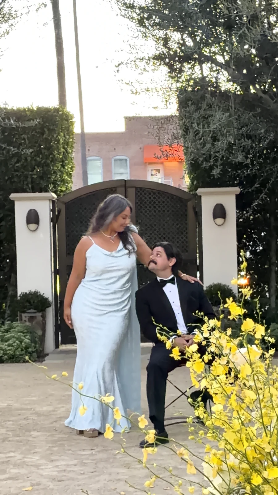 Couple sharing a playful moment in a flower-filled garden